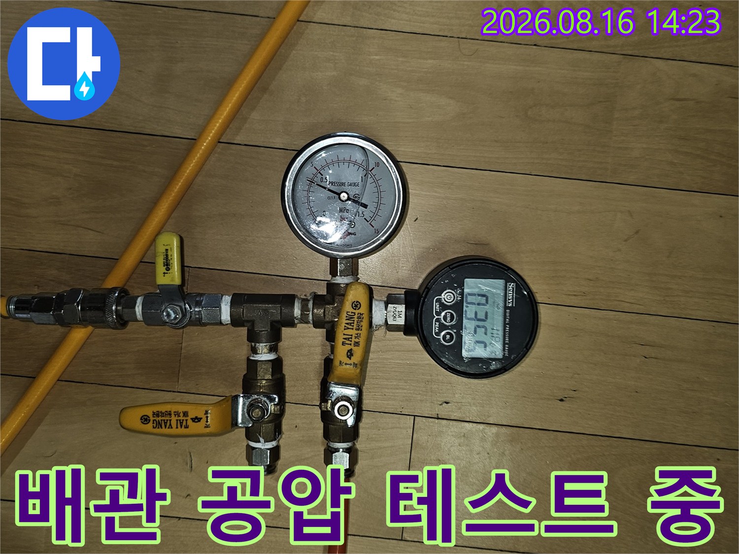 노란색 호스와 압력계를 사용하여 배관의 기밀 상태를 점검하는 모습