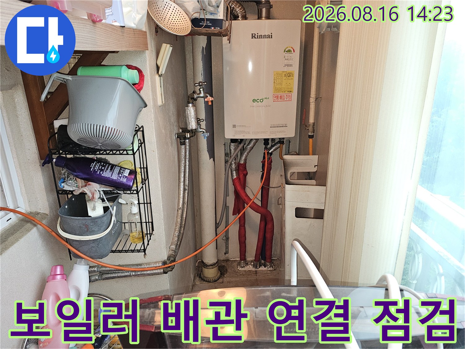 보일러 하단에 연결된 여러 갈래의 배관들을 집중적으로 확인하고 있습니다.