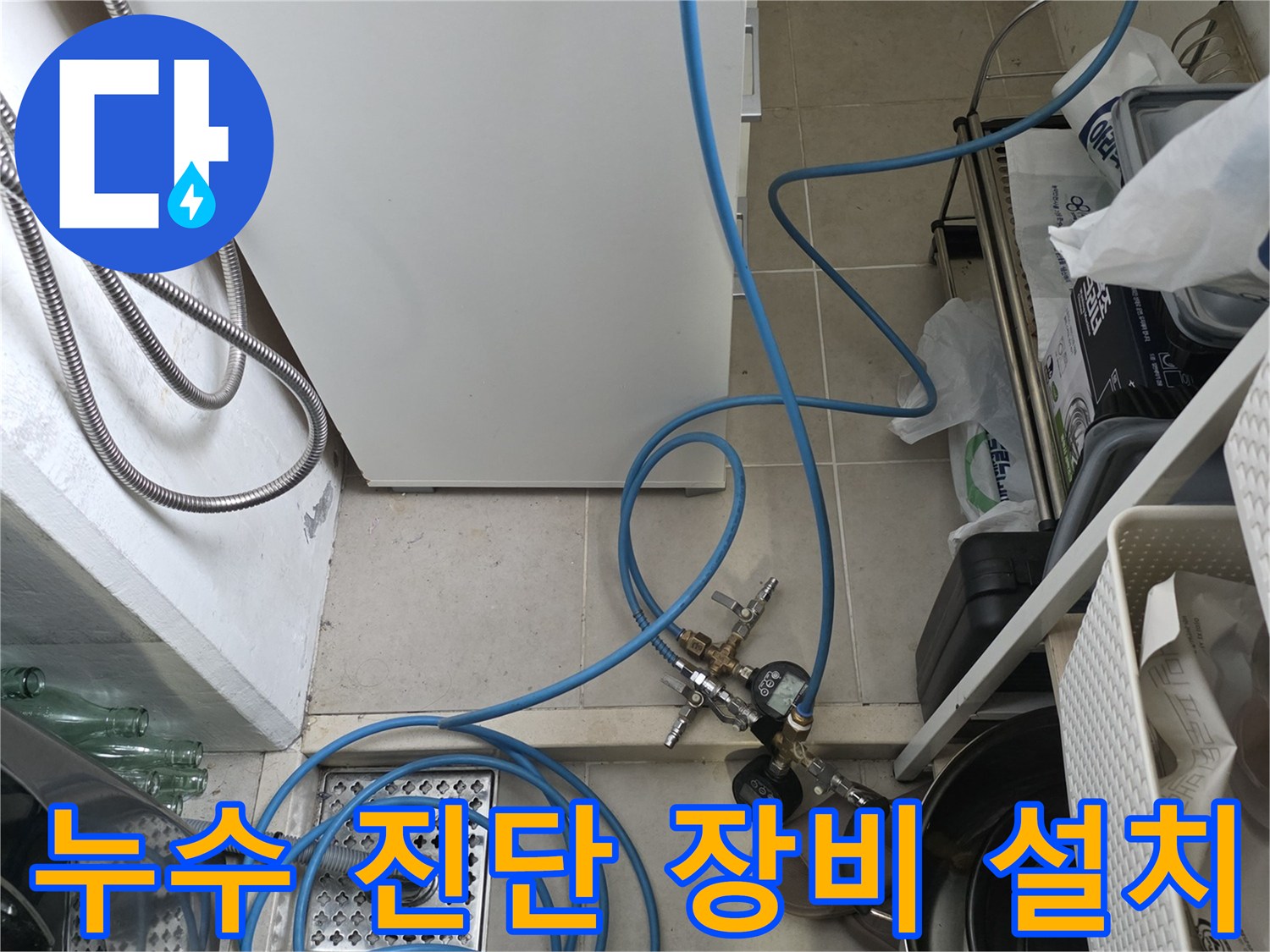 정수기 배관 점검-압력계를 연결하여 누수 여부를 확인하는 싱크대 하부 모습
