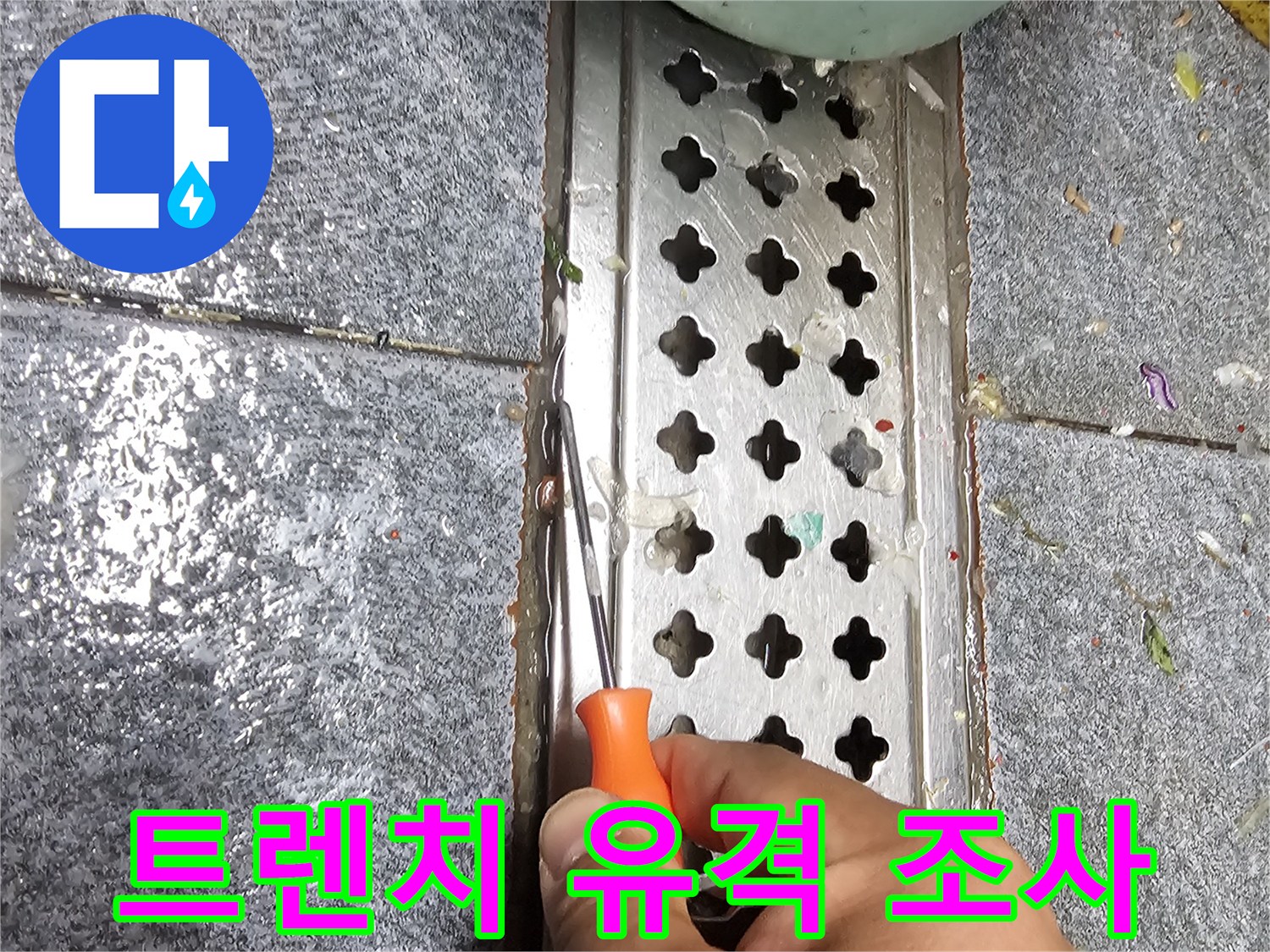 드라이버로 트렌치 주변 타일 틈새를 정밀하게 파헤쳐 점검하는 엔지니어의 손