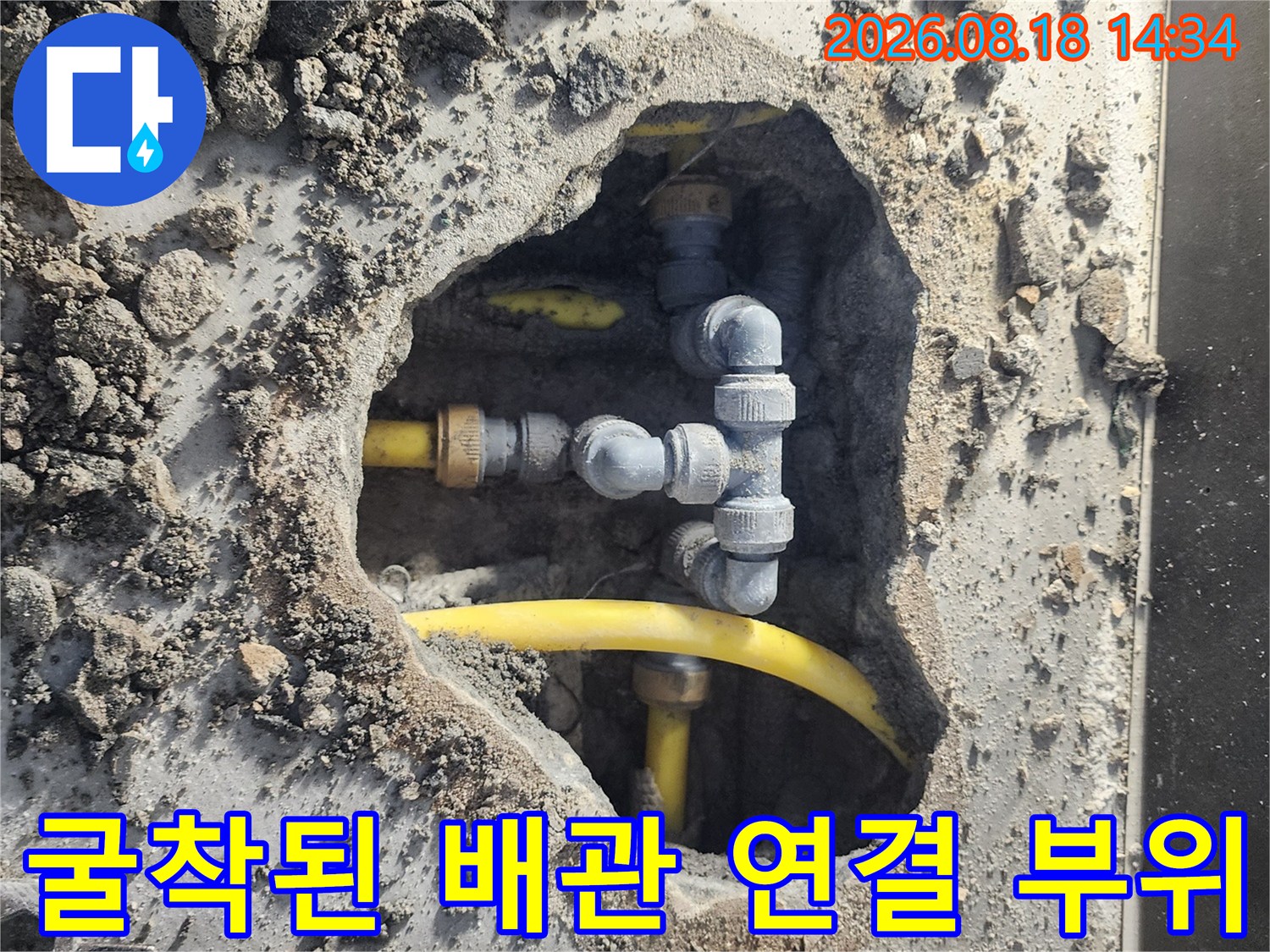 흙을 파내어 드러난 노란색 배관과 회색 부속의 연결 상태