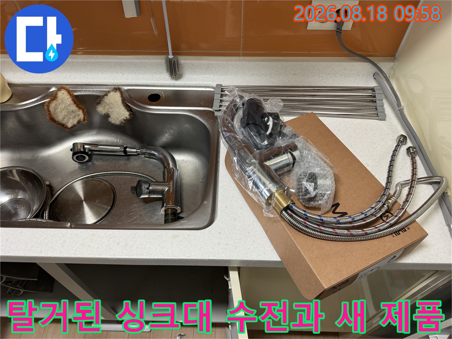기존에 사용하던 낡은 싱크대 수전이 탈거되어 있고 옆에는 교체할 새 수전 제품이 놓여 있습니다.