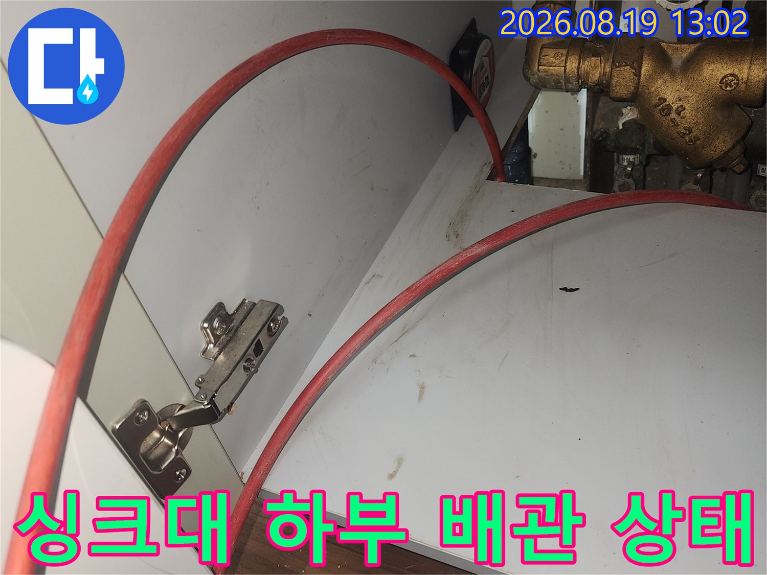 고양시 화정동 싱크대 하부장 내부의 수도 배관과 붉은색 호스 연결 부위 점검 모습