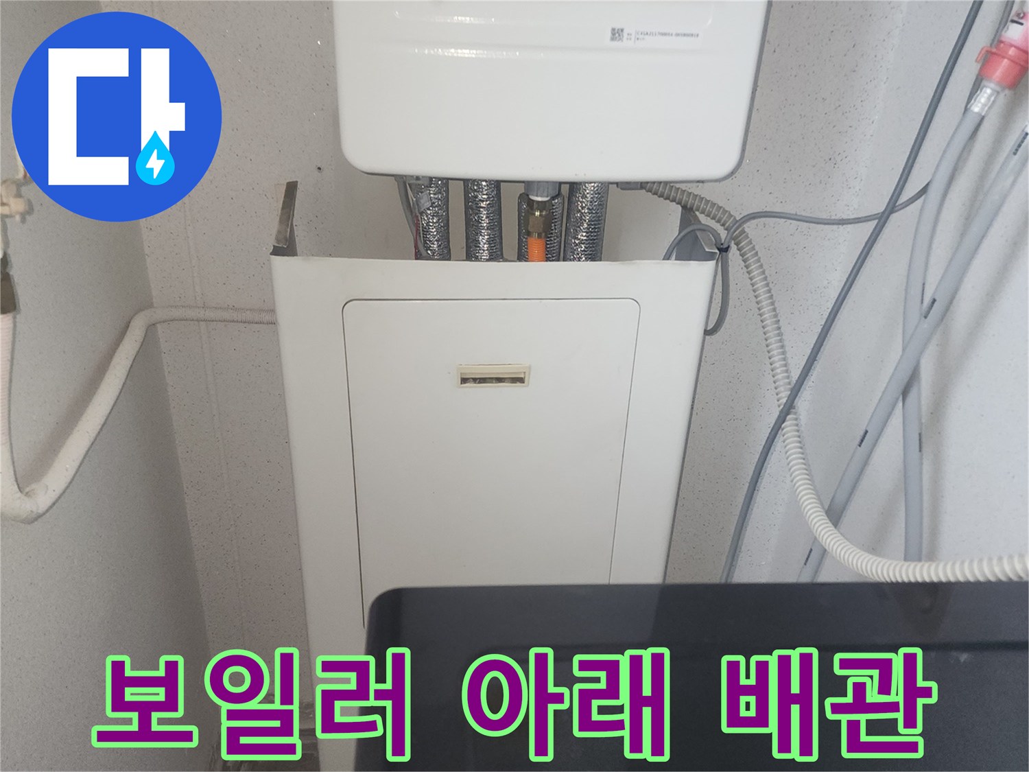 보일러-하부의-급수와-온수-배관이-연결된-부분을-근접 촬영한-사진
