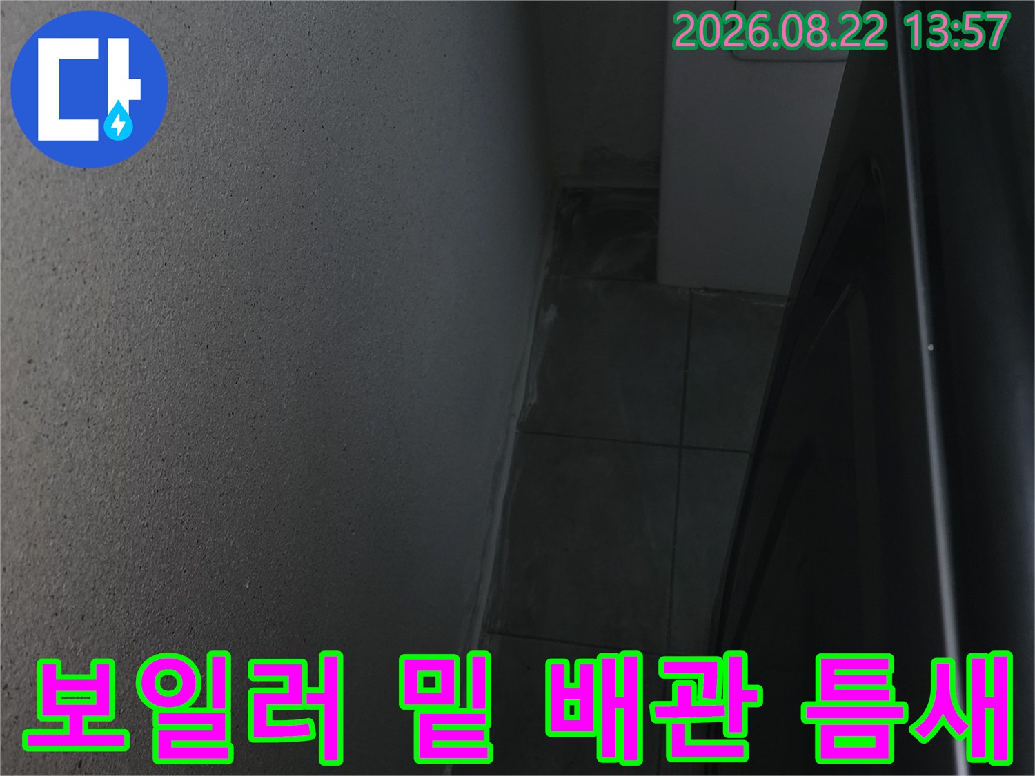 어두운 보일러 하단 공간의 타일과 배관 주변부 사진