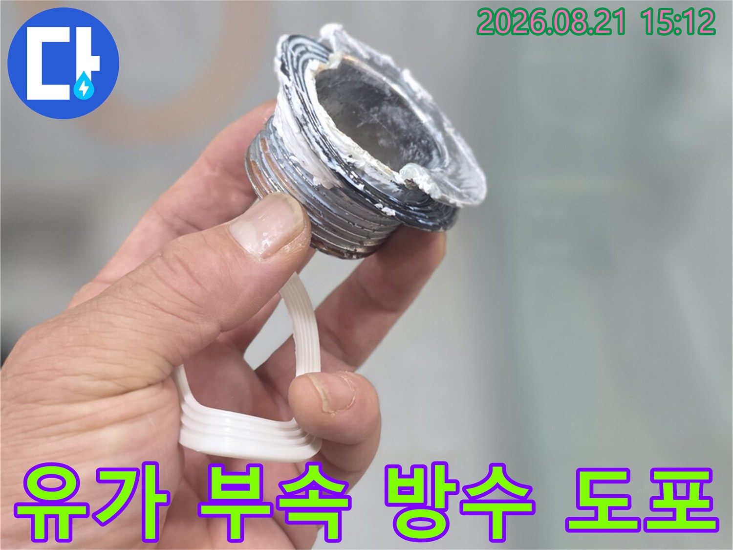 손으로 들고 있는-하얀색 실란트가 묻은 배수구 나사산
