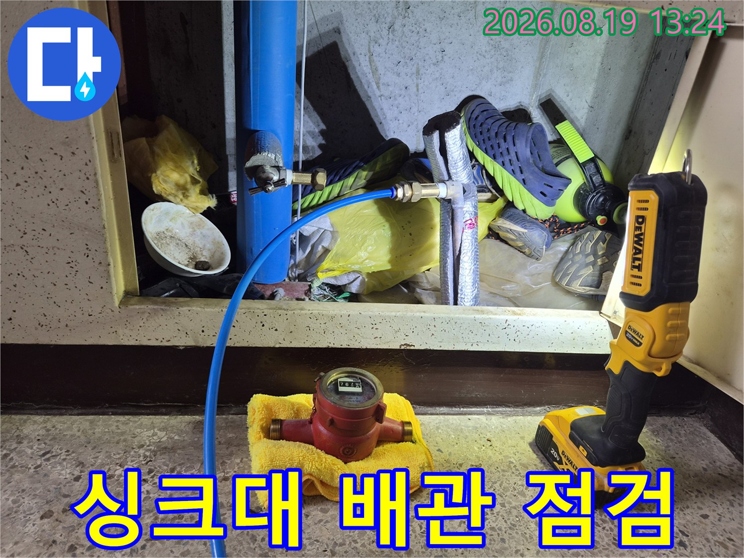 파란색 수도 배관과 계량기 장비가 보이는 작업 현장입니다.