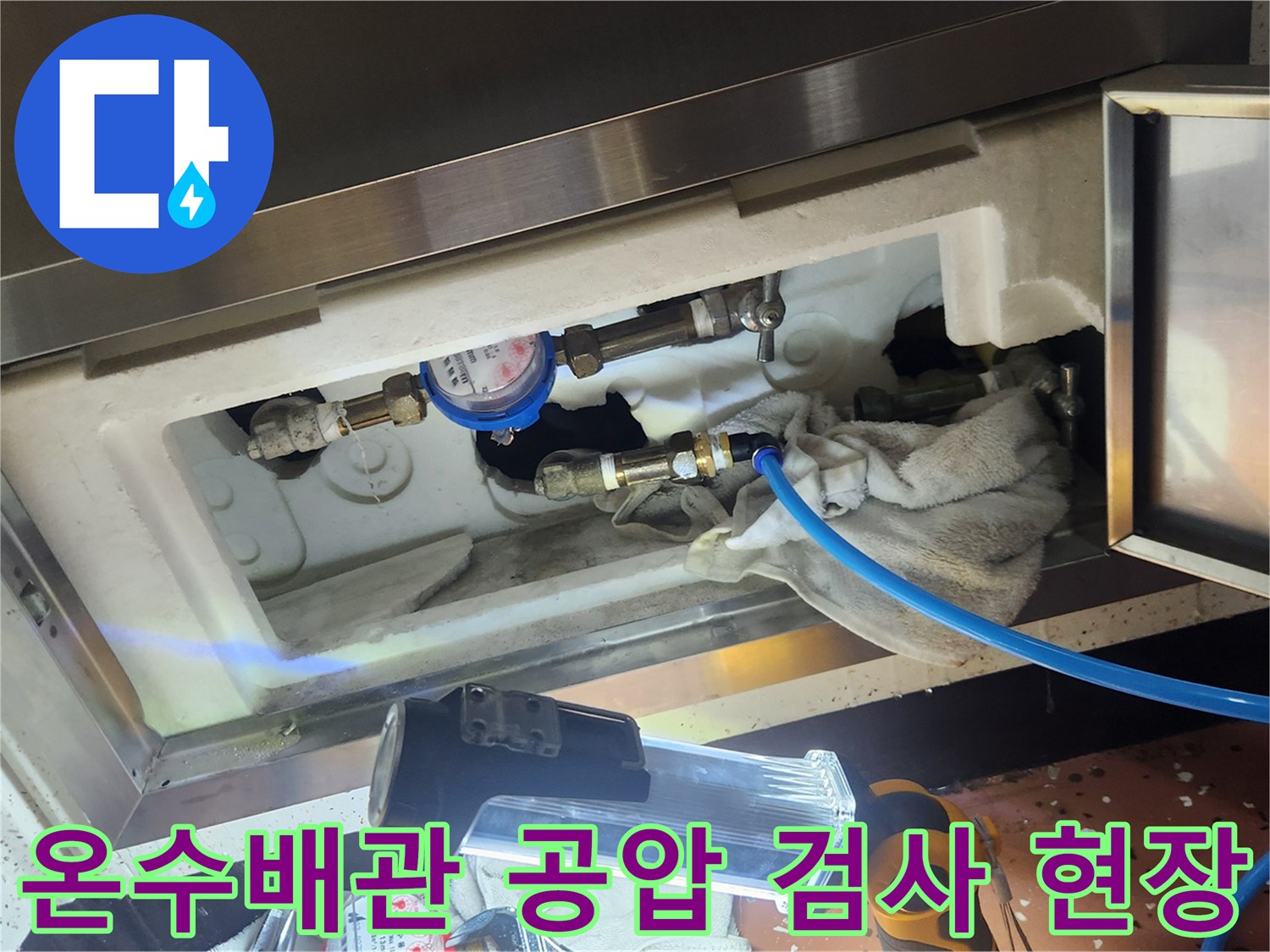 욕실 천장 내부의 온수 배관에 압력계를 연결하여 공압 검사를 진행하는 모습입니다.
