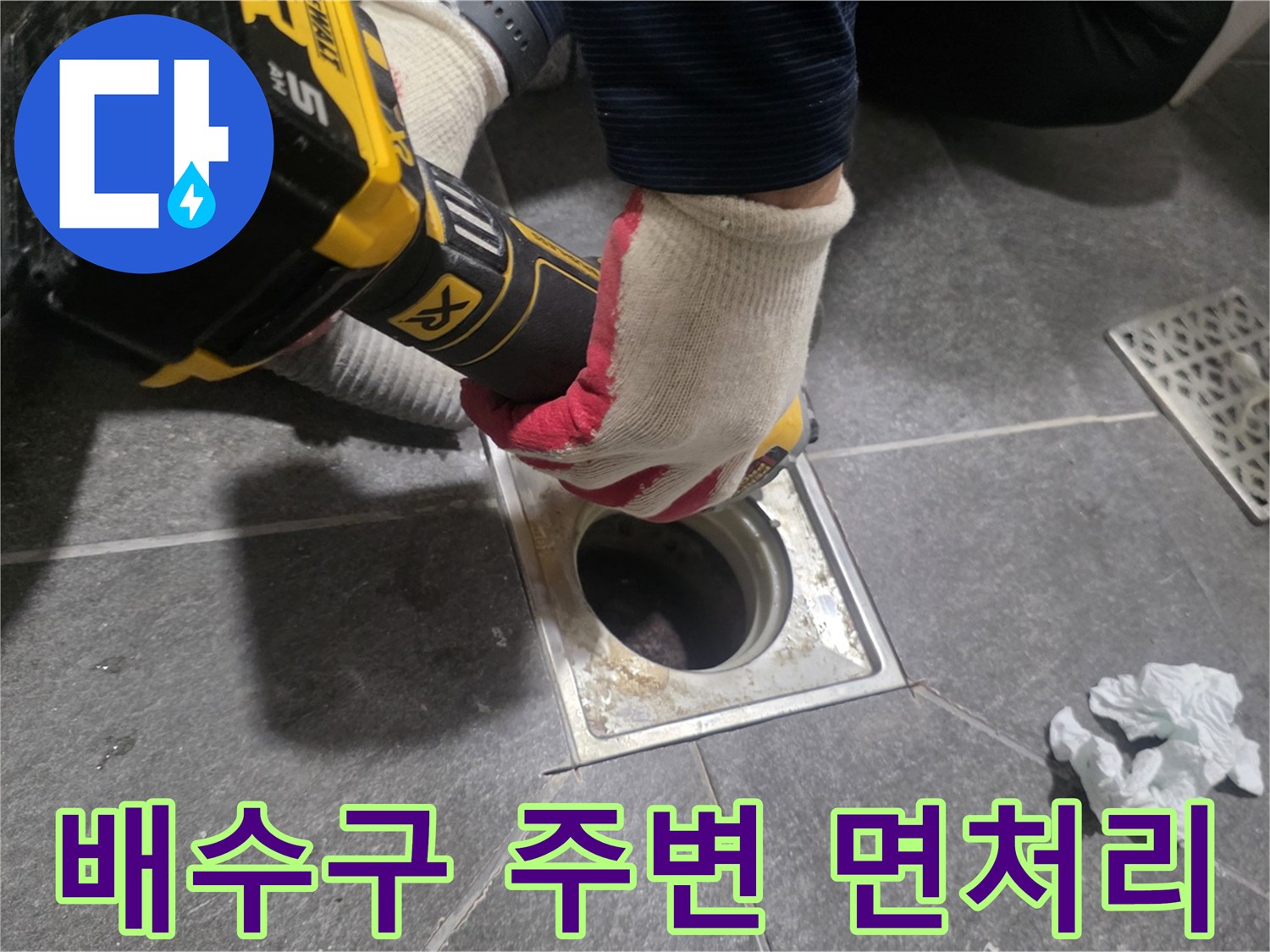 전동 공구를 사용하여 배수구 주변의 오염된 방수층을 제거하는 작업 장면입니다.