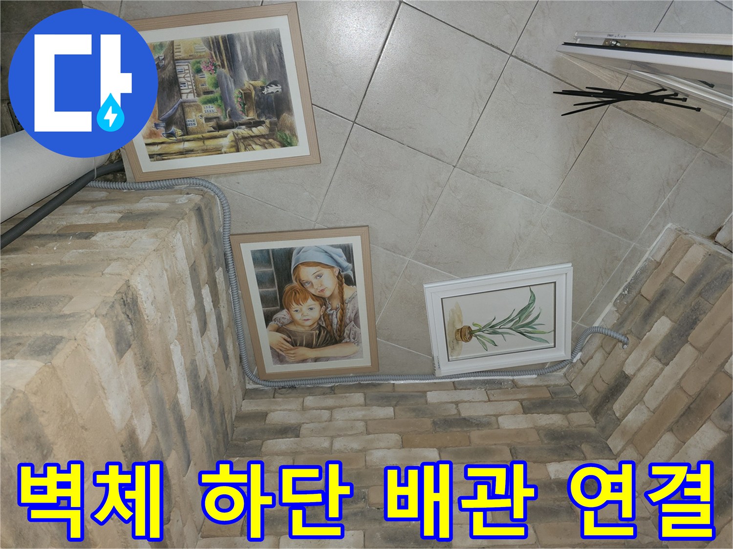 벽돌 구조물 아래쪽으로 이어지는 에어컨 드레인 호스 설치 모습입니다.
