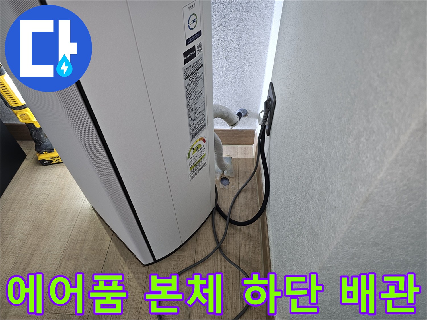 에어컨 기기 아래쪽으로 연결된 흰색 드레인 호스