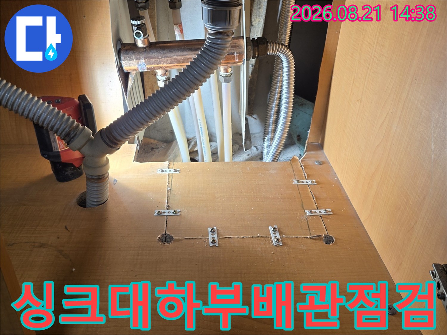 싱크대 하단부의 금속 배관과 주름관 연결 부위 근접 촬영