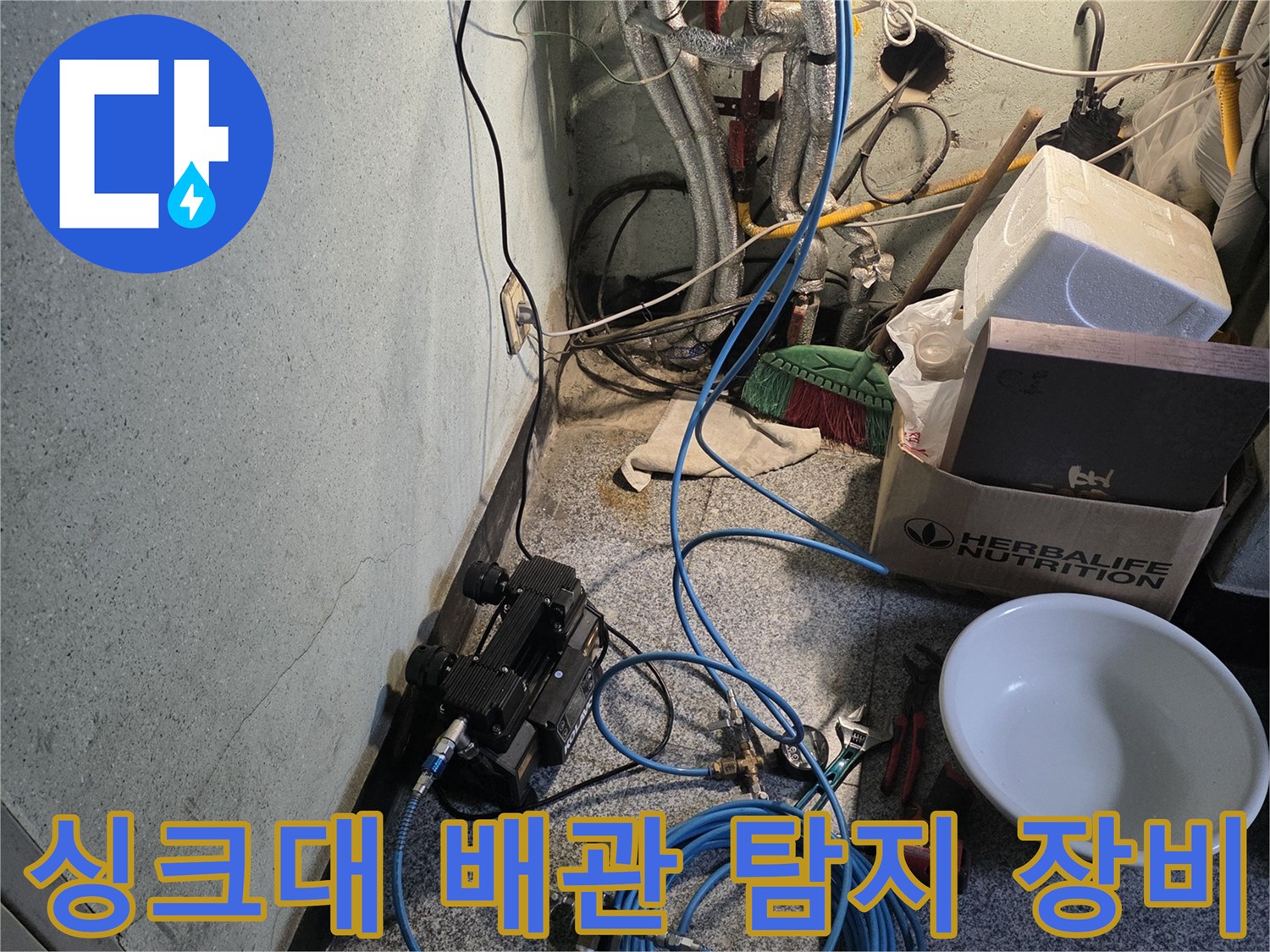싱크대 하부장 내부의 배관들과 압력 측정용 호스