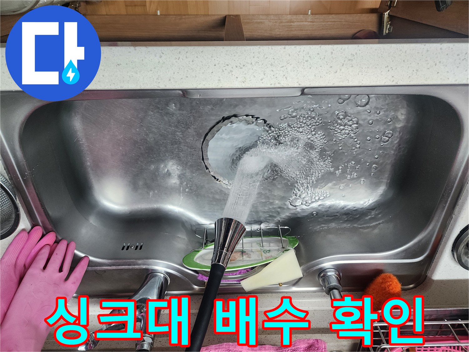 싱크대 수전에서 물을 틀어 배수 상태를 관찰하는 중입니다.