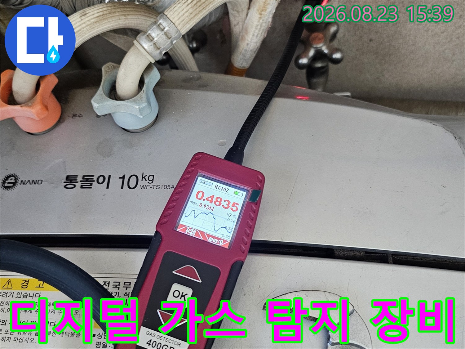 숫자가 표시된 휴대용 가스 탐지기와 배관 부속품들