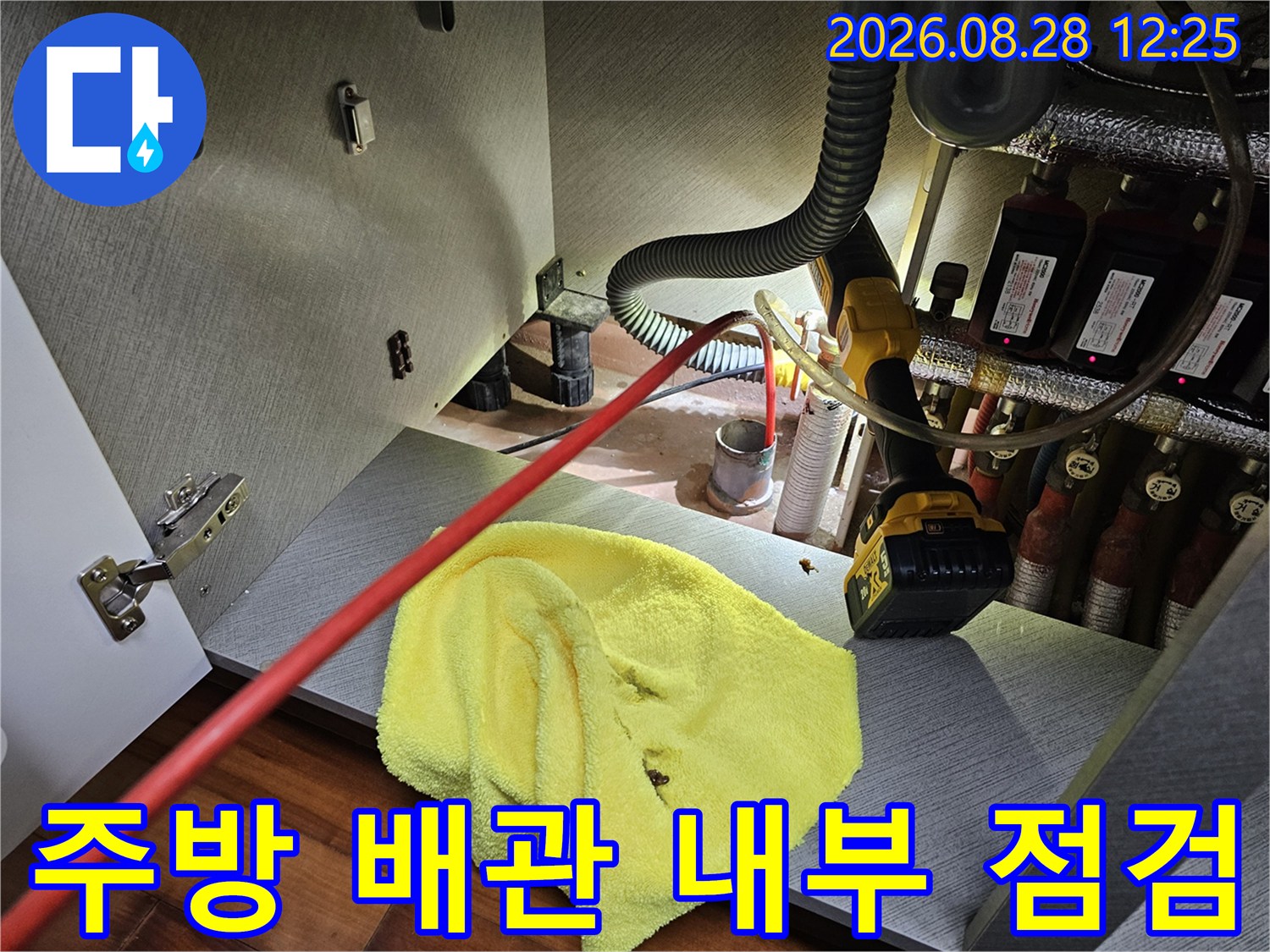 싱크대 하부 배관 연결 부위와 분배기를 정밀하게 검사하는 장면-누수 지점 추적 중