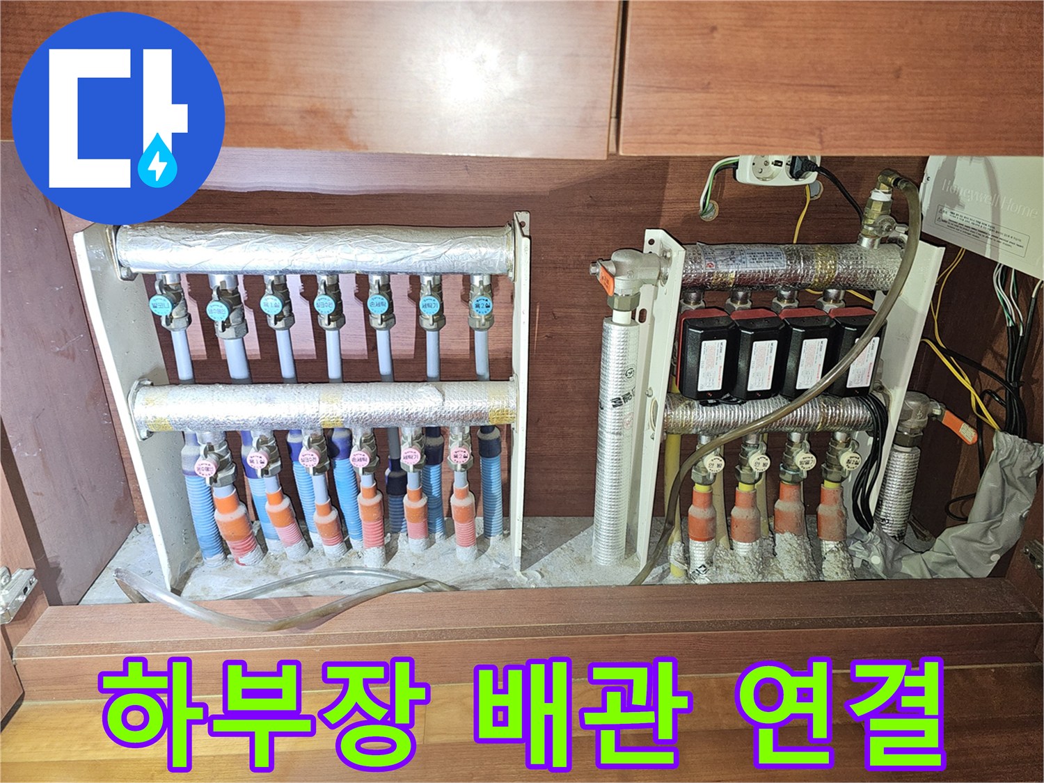 싱크대 하부 분배기와 은색 보온재로 감싸진 배관들