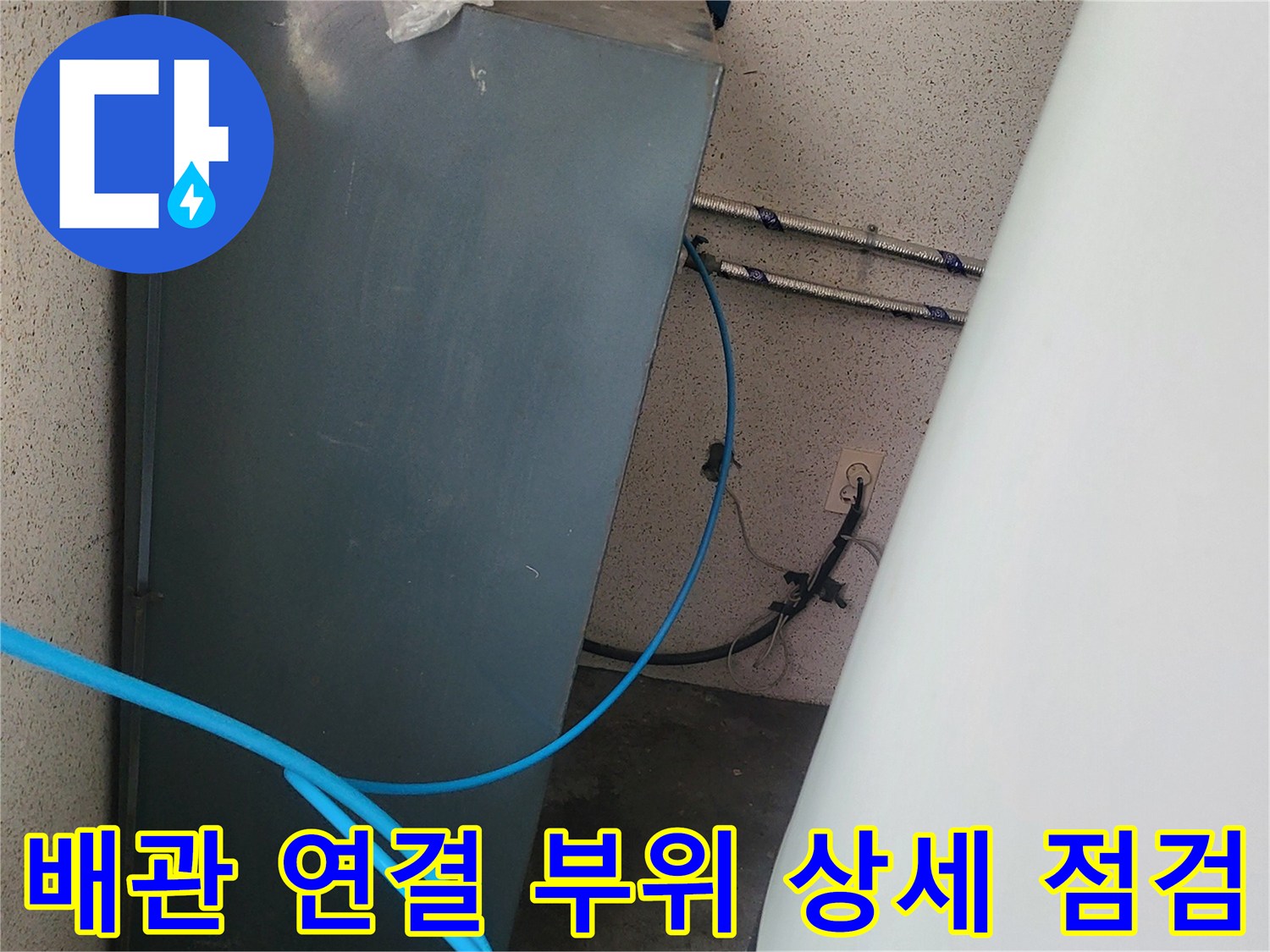 금속 탱크 옆으로 지나가는 파란색 호스의 모습