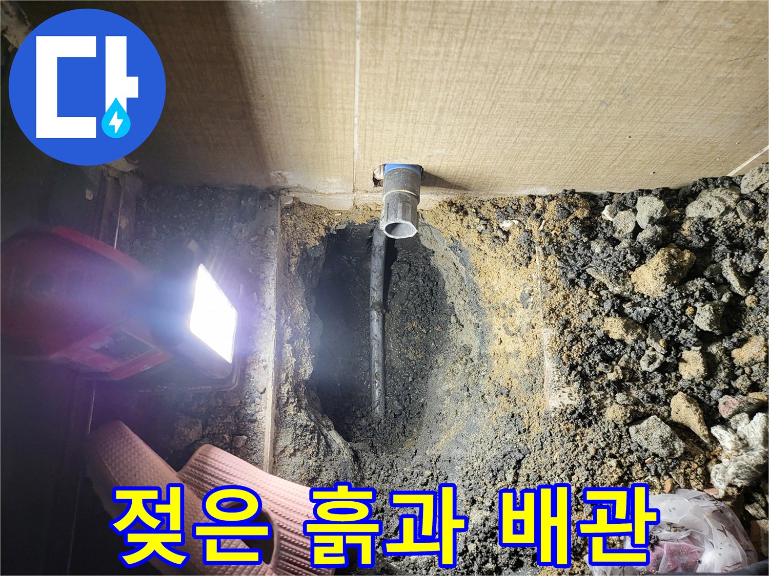 습기로 가득 찬 흙더미와 파란색 배관의 모습