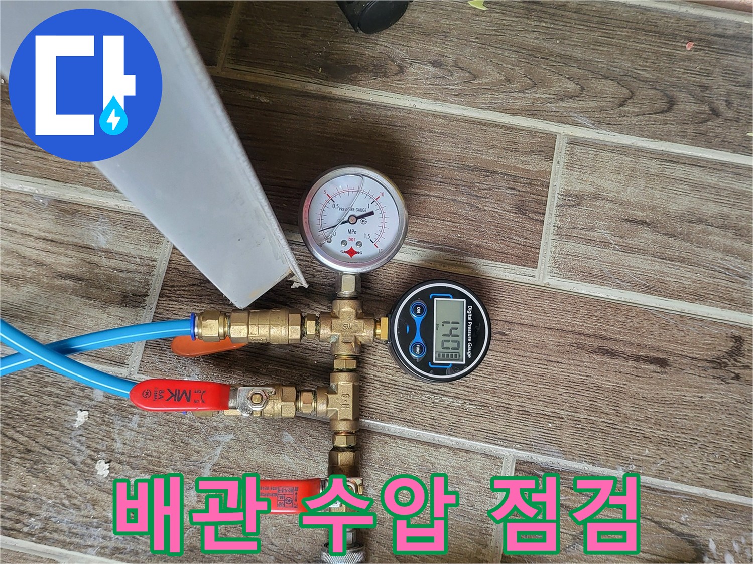 파란색 호스와 밸브가 연결된 배관 압력 측정 장치