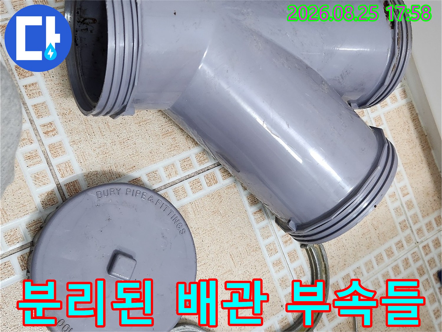 탈거 완료된 회색 오수관 부속과 작업용 도구의 모습입니다.