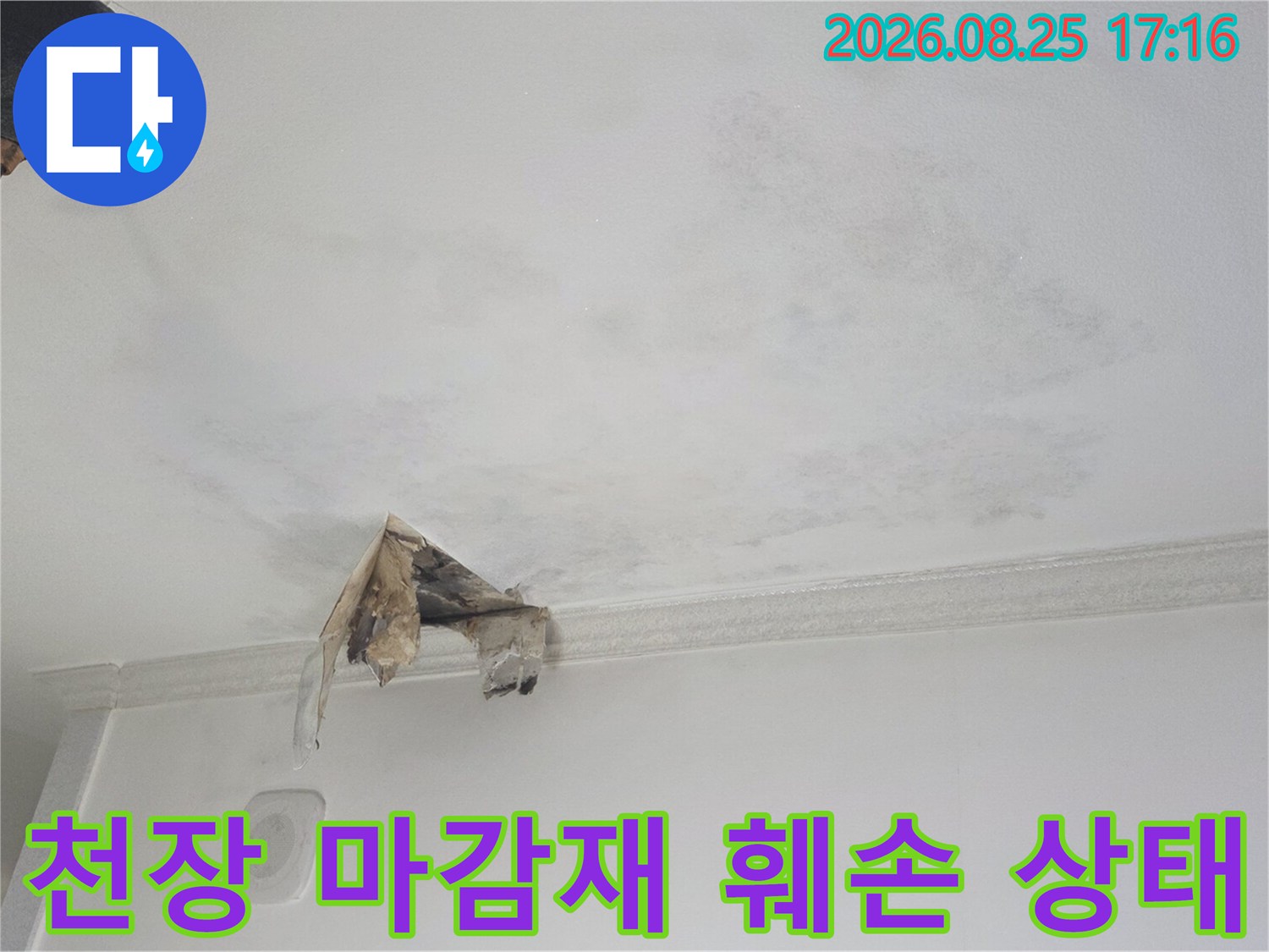 물에 의해 젖고 찢어진 천장 마감재의 근접 모습