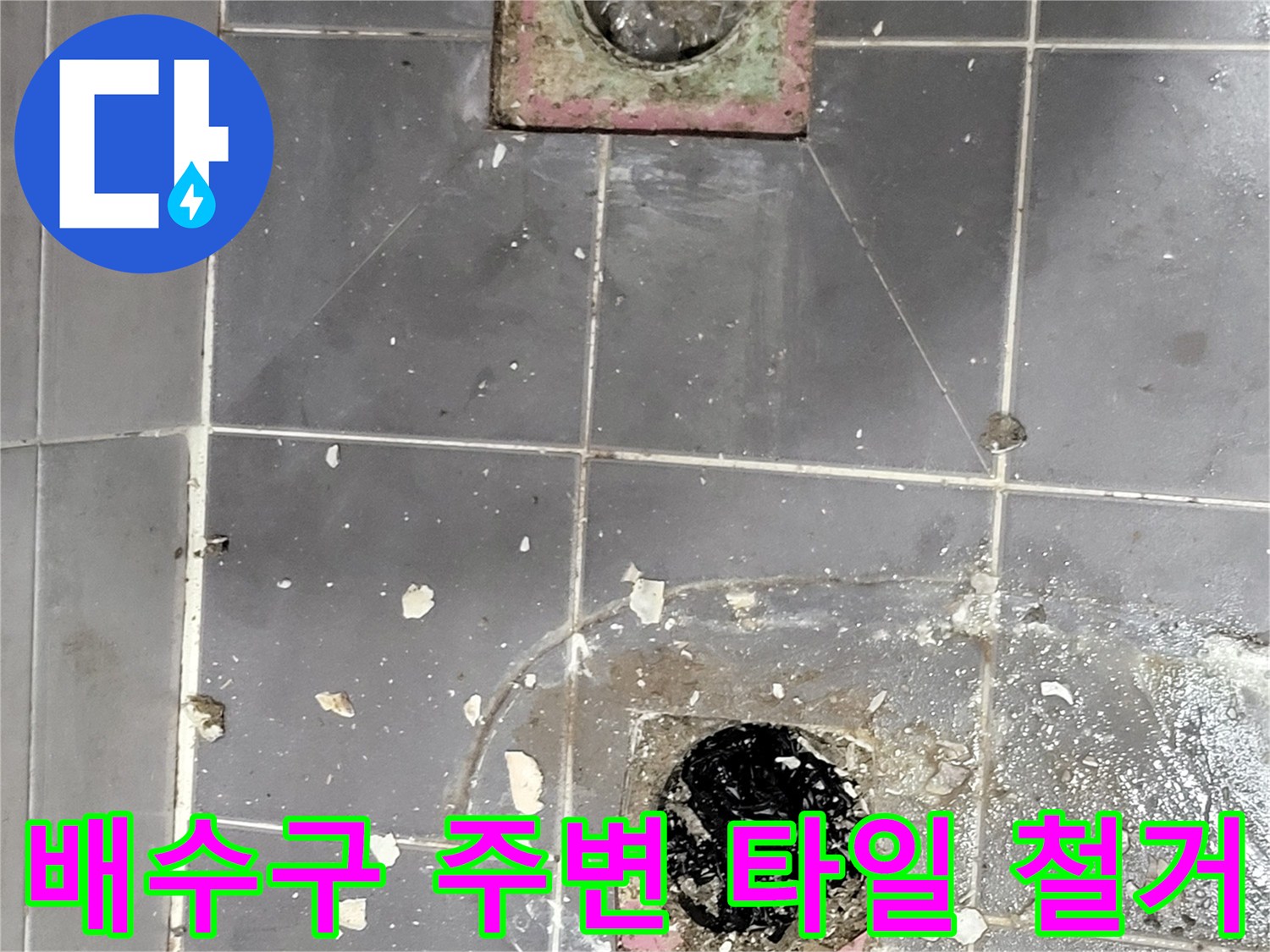 욕실 바닥 배수구 부근의 타일이 제거된 작업 현장 모습