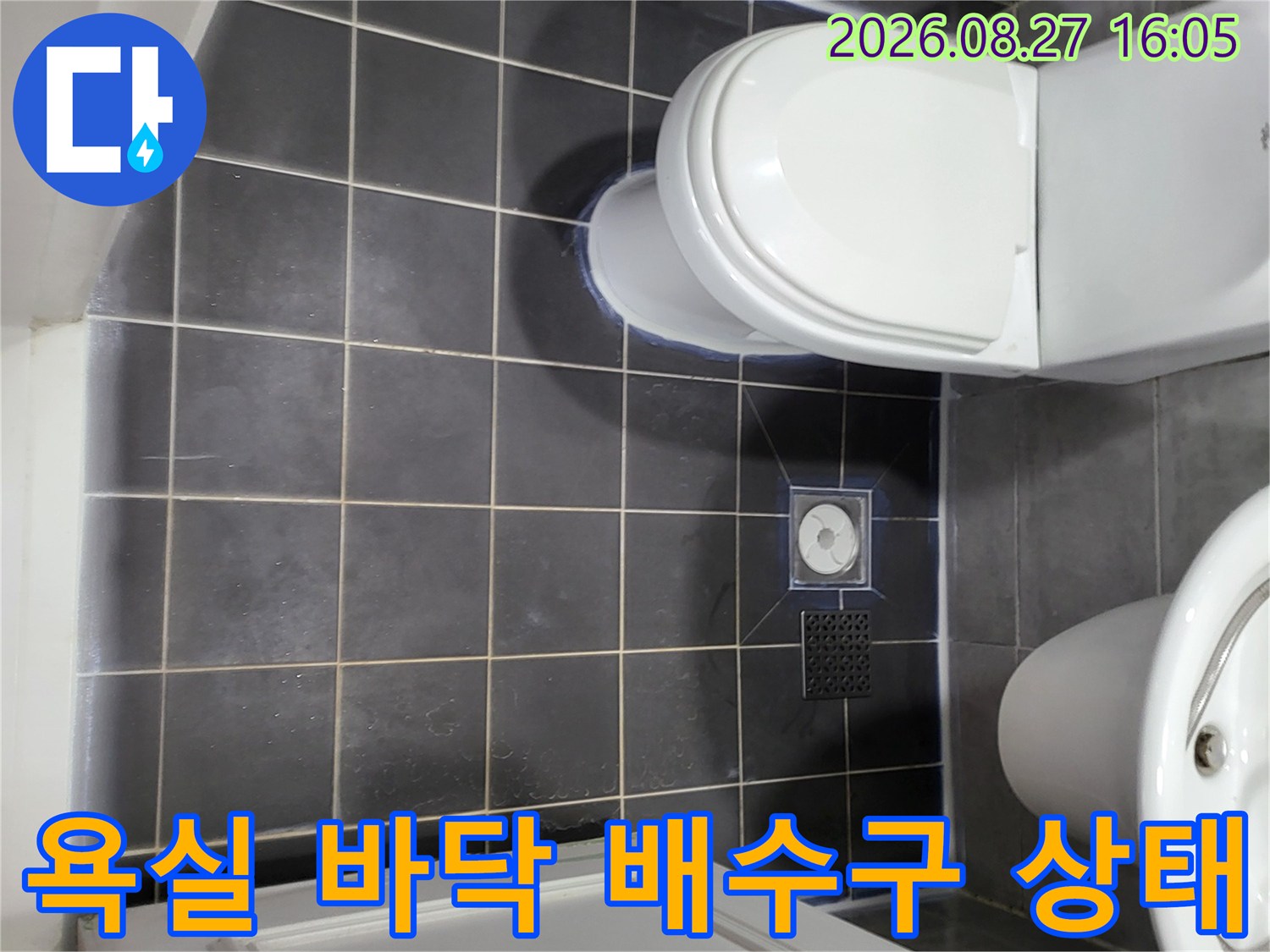 화장실 변기 옆-배수구와 세면대 아래의 타일 시공 모습입니다.