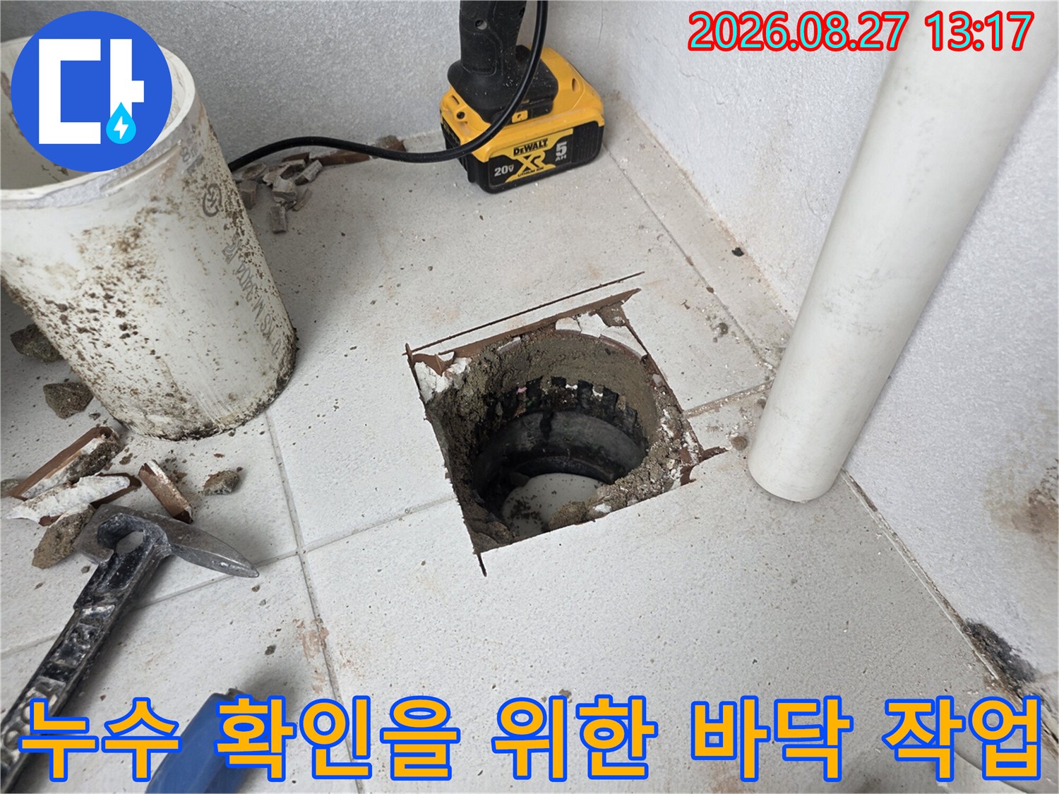 우수관 주변의 - 누수 경로를 차단하기 위해 타일을 제거한 모습입니다.