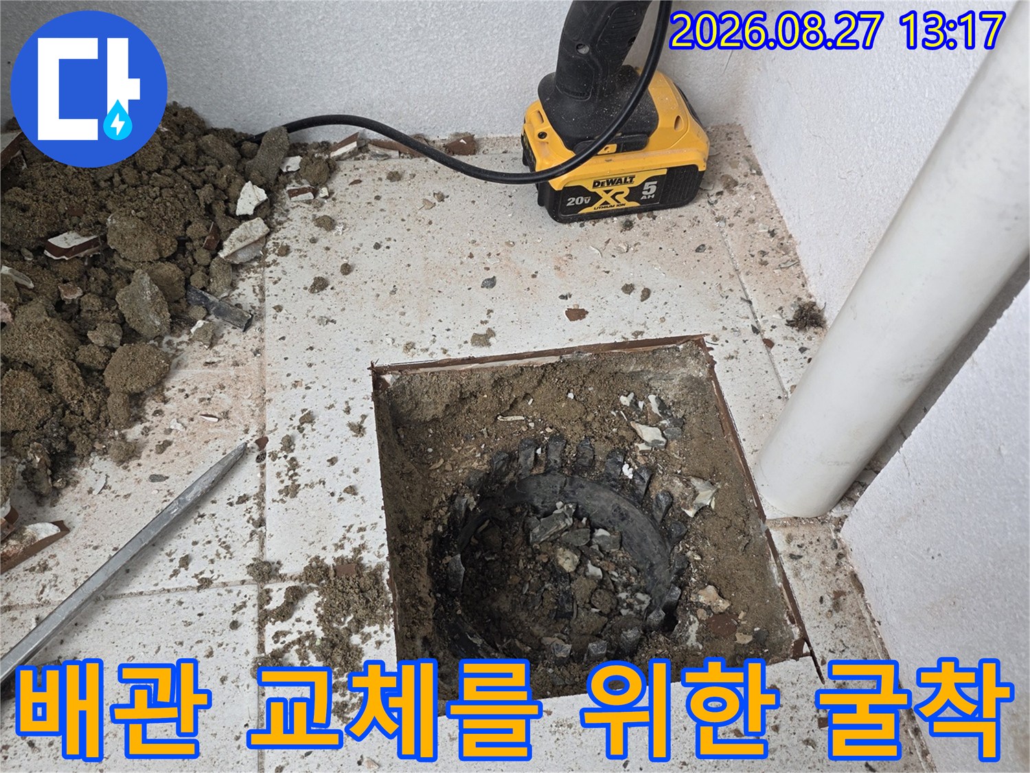 우수관 주변의 - 타일과 바닥재를 제거하여 노출된 배관 상태를 점검하는 장면입니다.