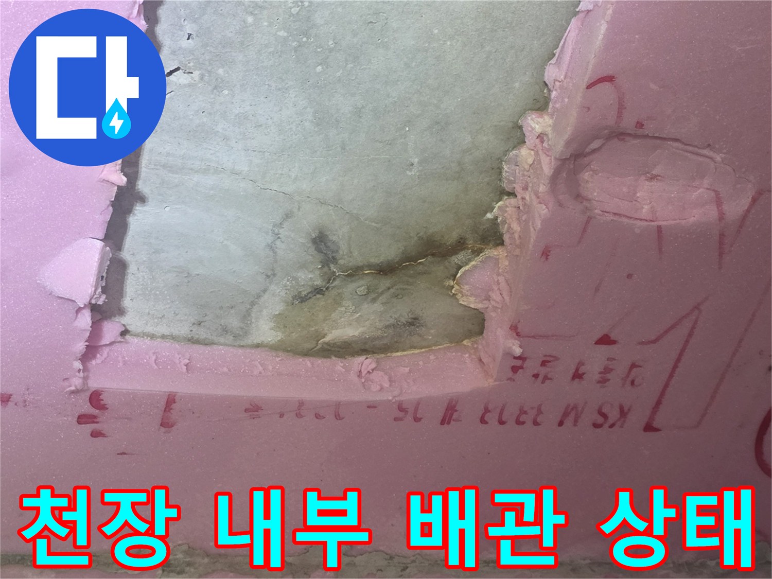 분홍색 단열재 사이로 보이는 배관 연결 부위와 콘크리트 틈새