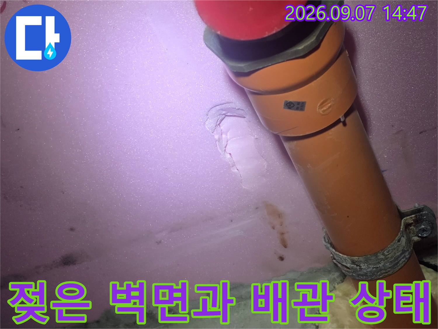 습기를 머금은-천장 마감재와 주황색 하수 배관의 모습