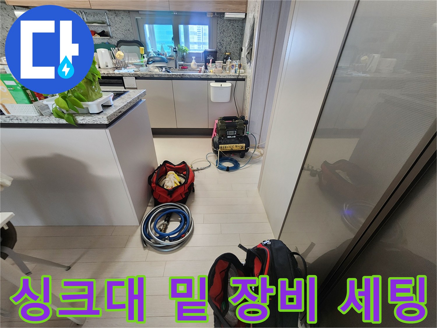 주방 싱크대 하부 공간에 놓인 누수 점검용 호스와 게이지