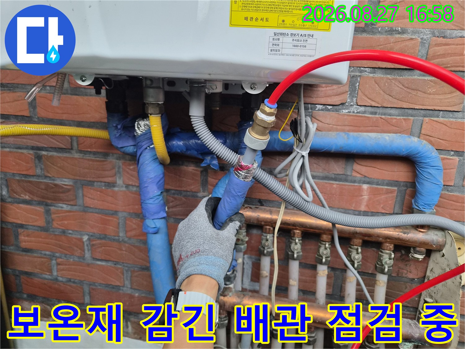 파란색 보온재-배관의 연결 부속을 손으로 확인하고 있습니다.