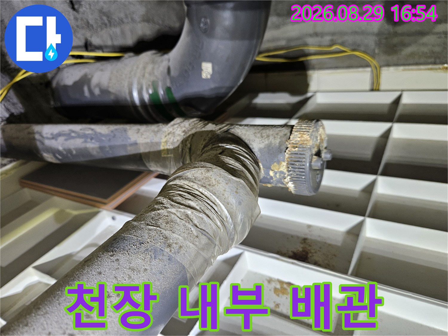 아파트 천장 구조물 사이로 보이는 누수 의심 배관의 모습입니다.
