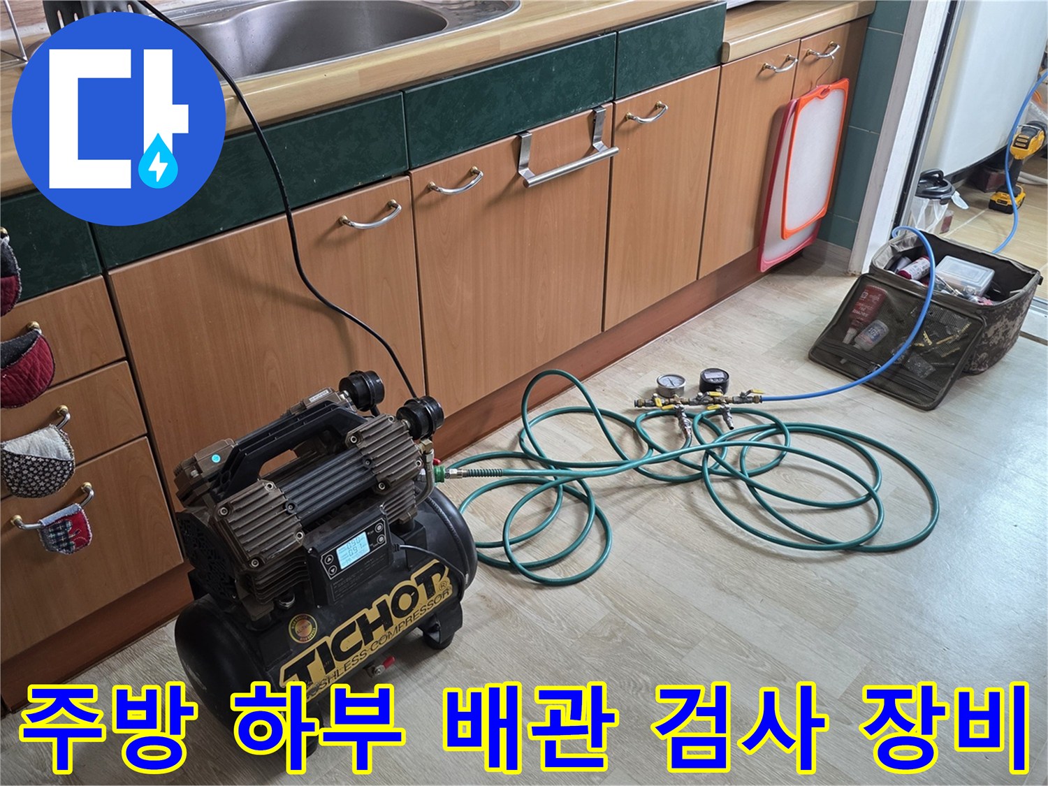 싱크대 아래 공간에 연결된 공기 압축식 누수 탐지 장비