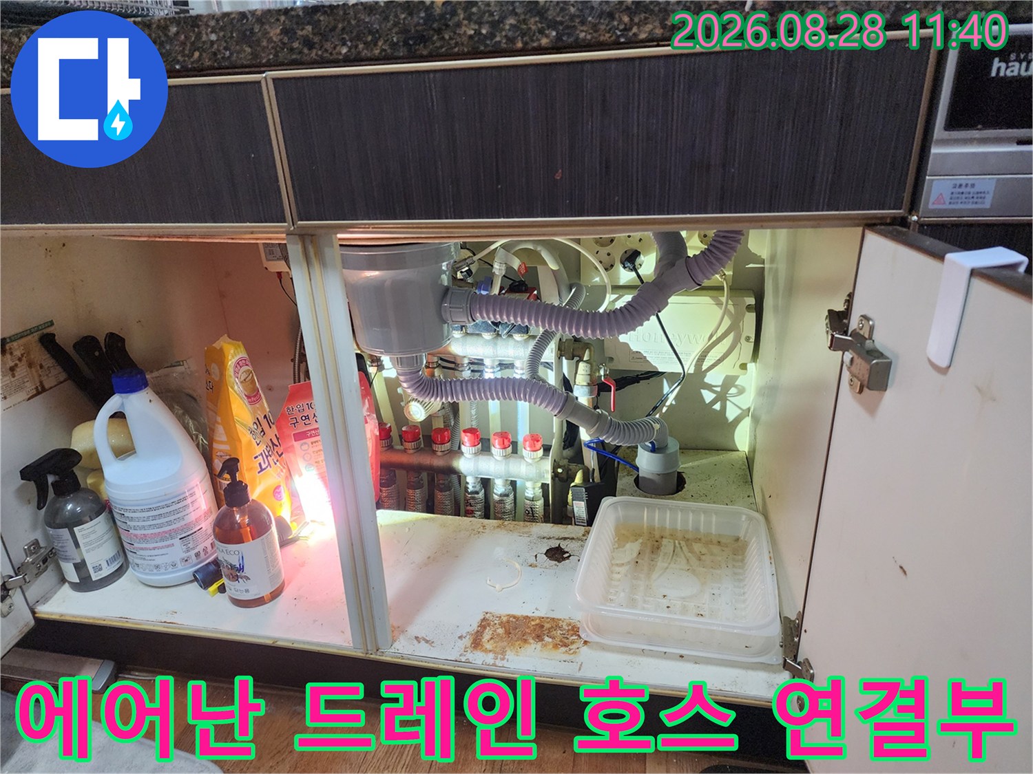 복잡하게 얽힌 에어컨 드레인 호스와 싱크대 배수관의 연결 부위입니다.