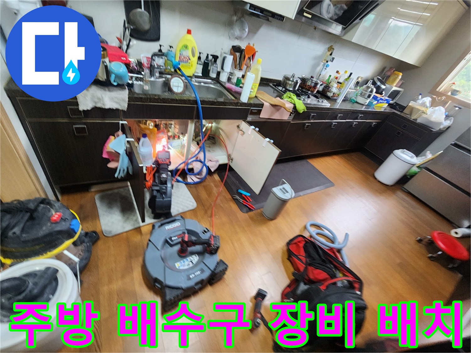 싱크대 아래쪽 배수관 점검을 위해 준비된 내시경 카메라와 작업용 도구들