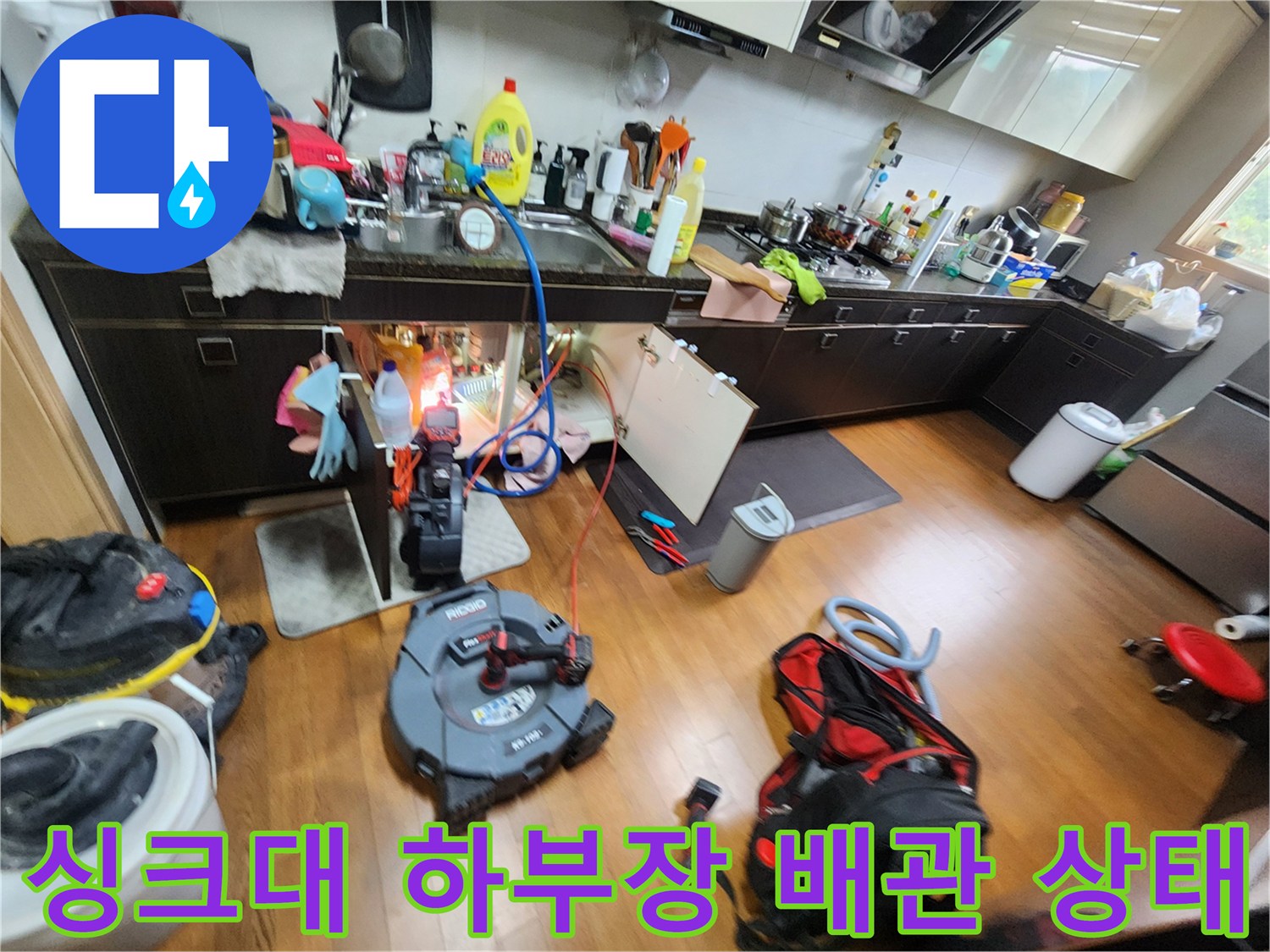 주방 싱크대 하단 배관 연결 부위와 검사 장비의 배치 모습