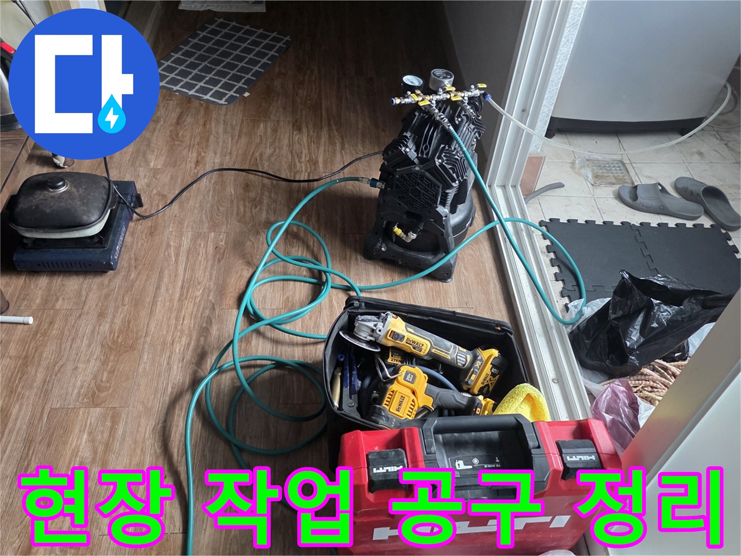 바닥에 놓인 청음식 탐지기와 배관 수리용 전동 드릴 케이스