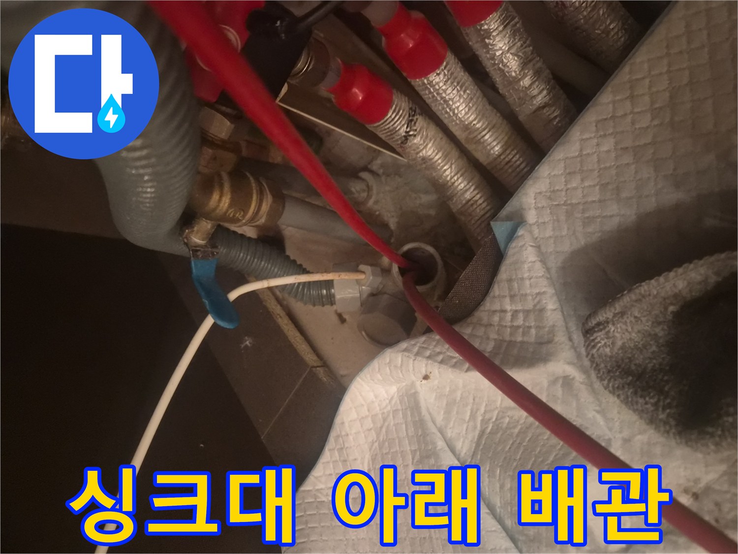 보온재가 입혀진 은색 배관과 붉은 호스가 있는 현장