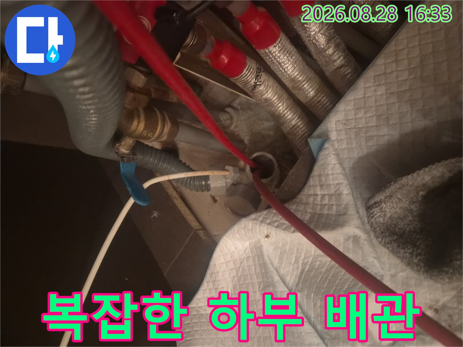 은색 보온재로-감싸진 여러 개의-싱크대 하단 배관들
