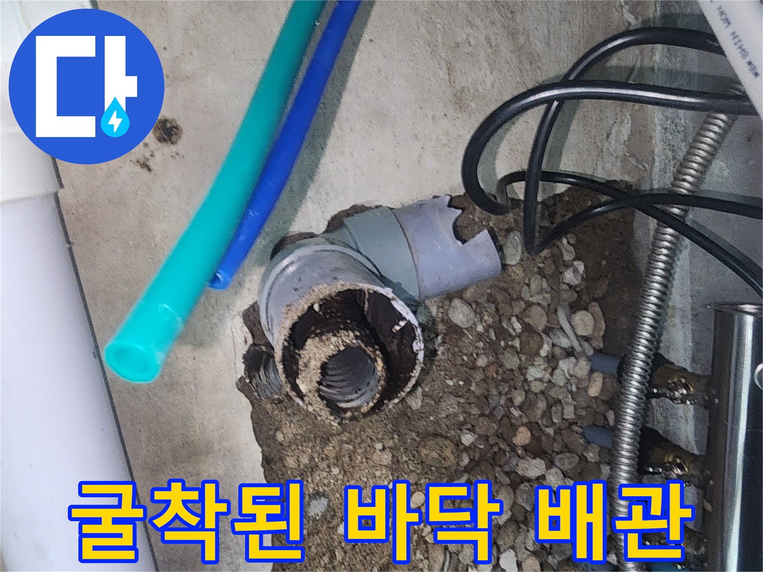 자갈과 흙 사이로 보이는-부식되어 파손된 분배기 배관