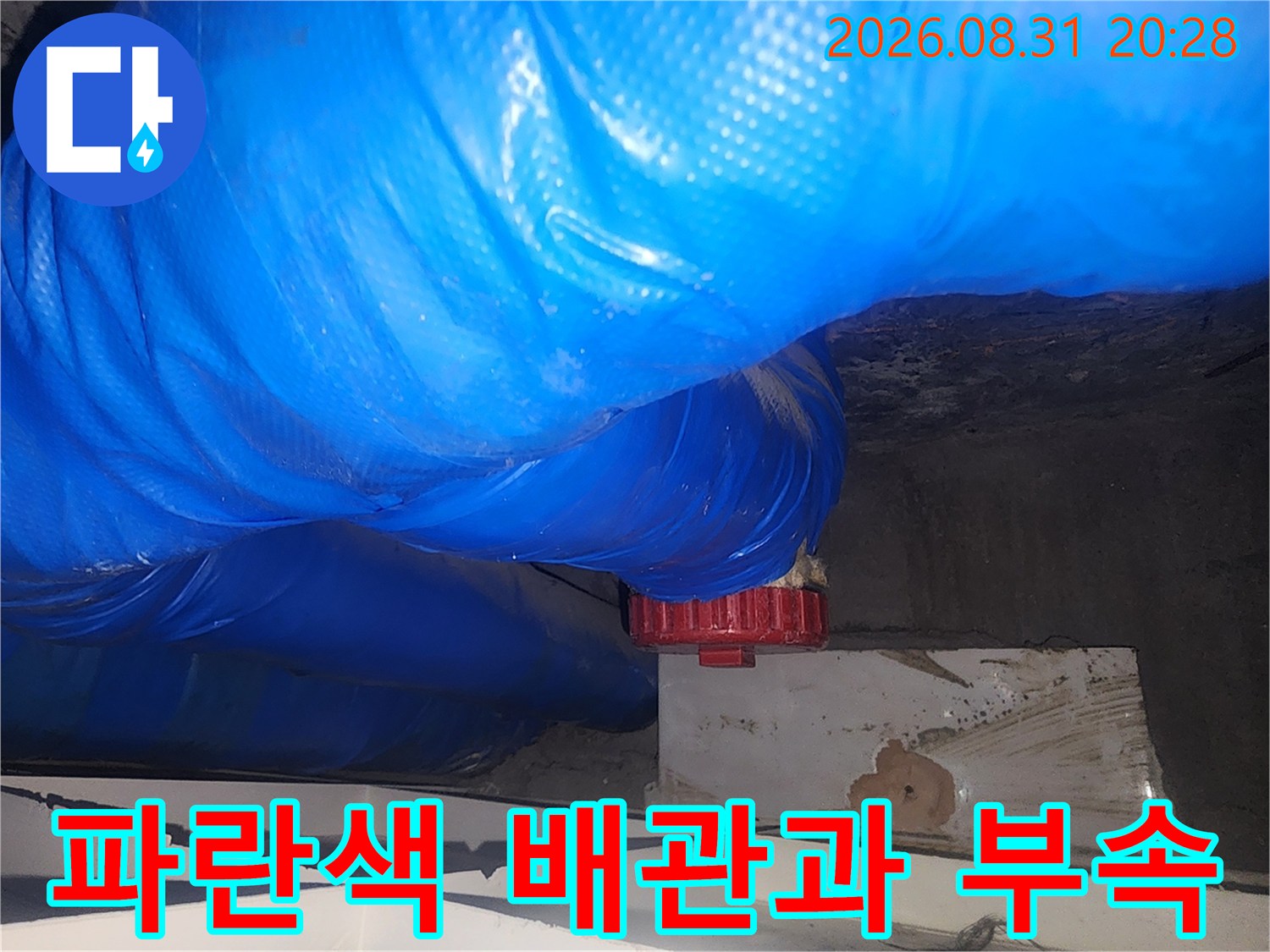 파란색 덮개가 씌워진-하수관 연결 부위의 누수 수리 작업