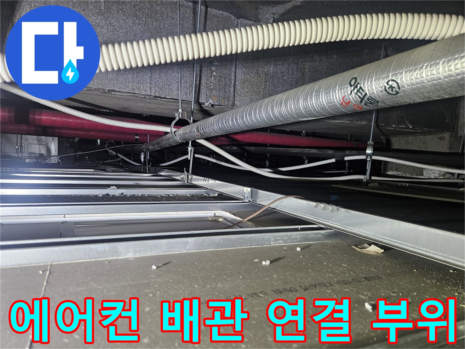 천장 텍스 안쪽-얽혀 있는 드레인 호스와 은색 보온재 마감 관로