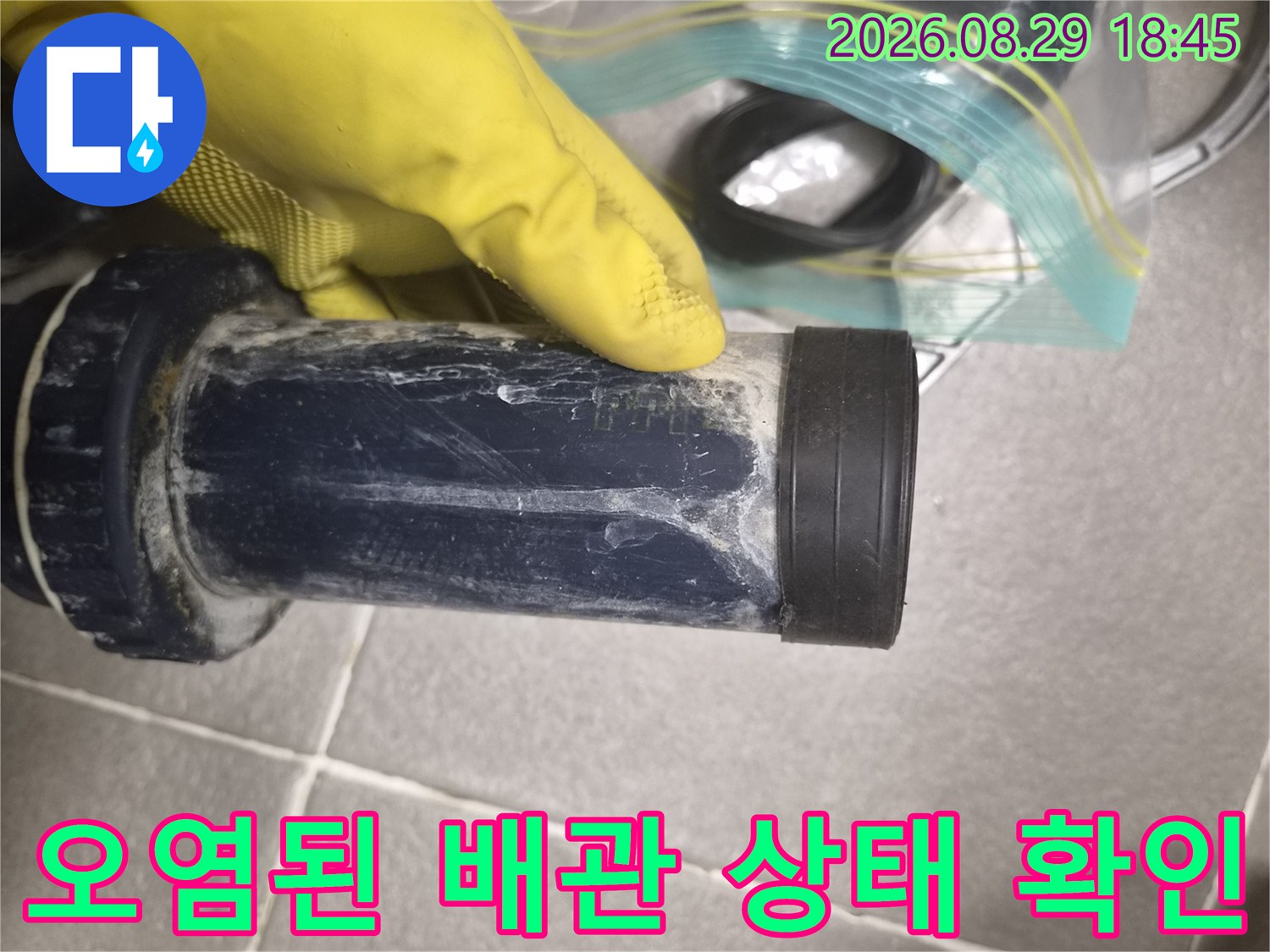 물기가 남아 있고 얼룩이 심한 배관 연결 부위를 점검하고 있습니다.