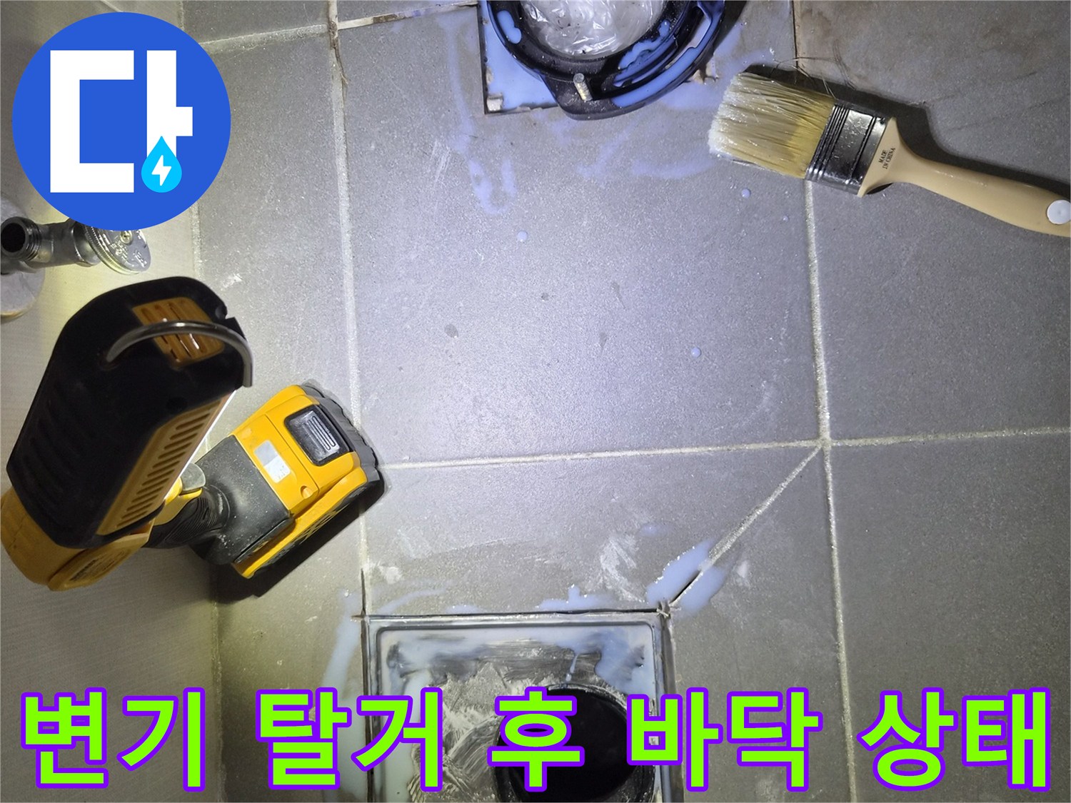 변기를 들어낸 자리의 배관 주변과 타일 상태를 보여주는 사진입니다.