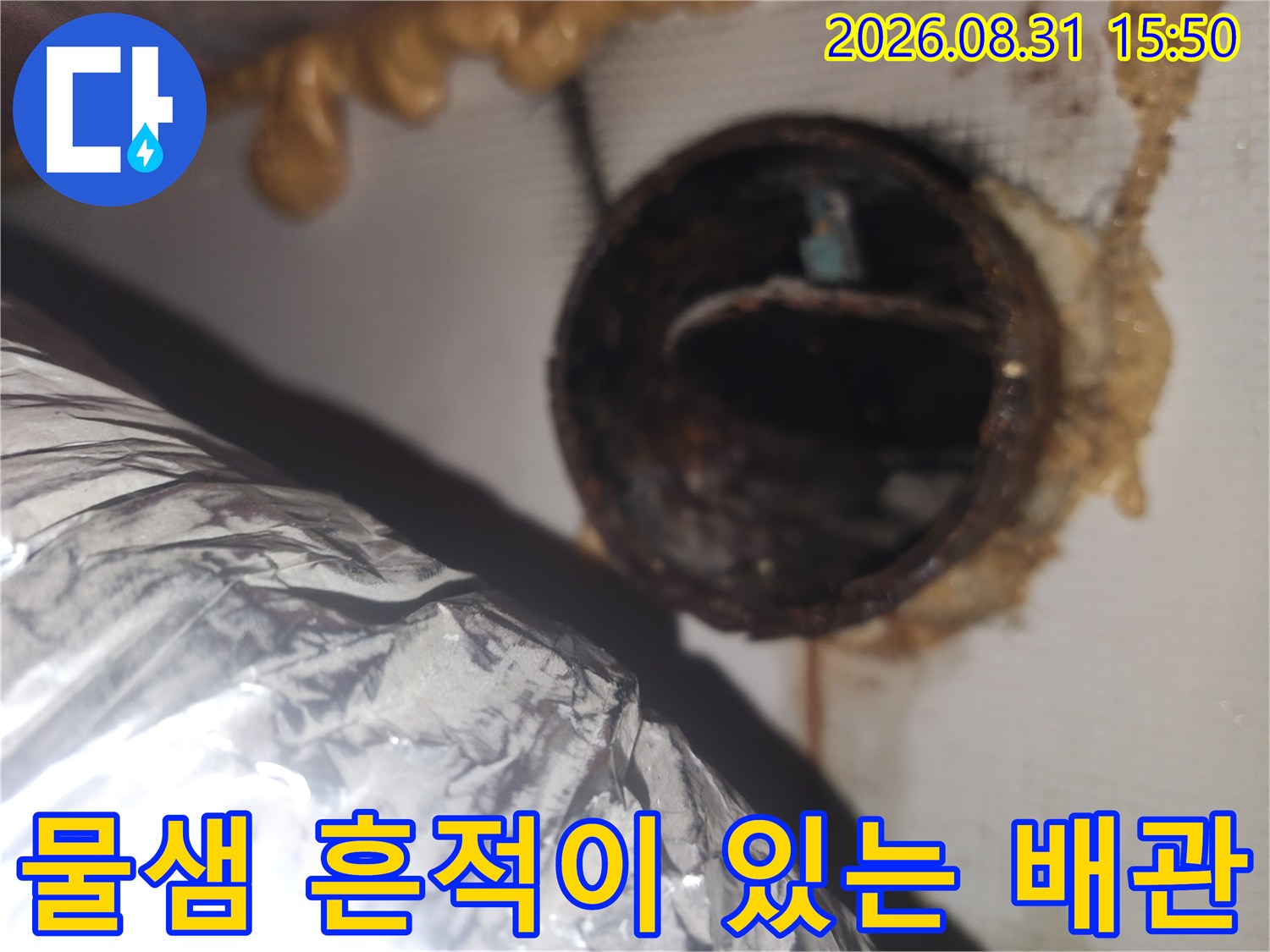습기와 누수로 인해 변색된 화장실 천장 환풍기 배관 연결부