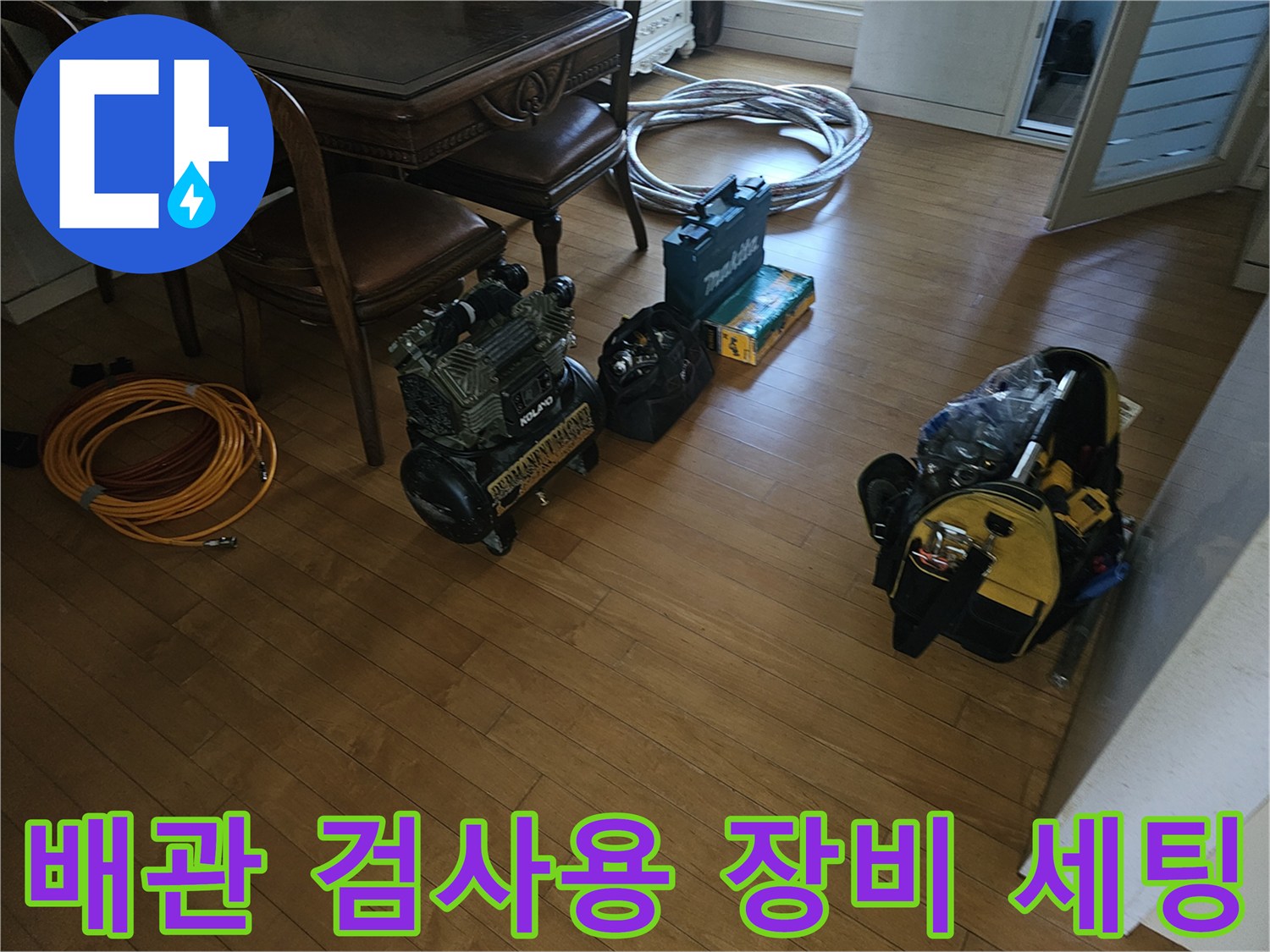 공압 테스트기와 배선 및 각종 도구가 놓여 있는 공사 현장 바닥