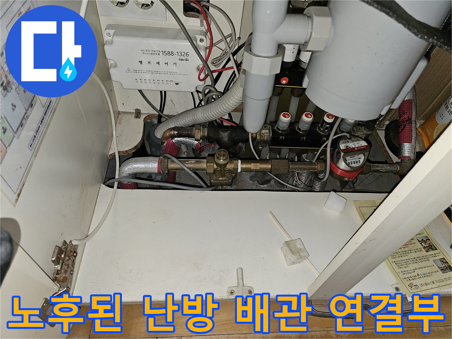 금속 재질의 노후된 난방 배관과 분배기가 복잡하게 연결된 내부 모습입니다.